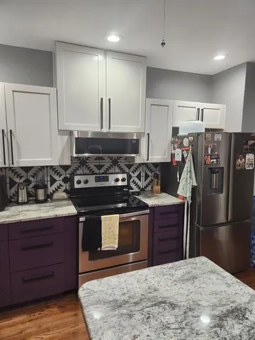 a kitchen with stainless steel appliances granite countertop a stove and a refrigerator