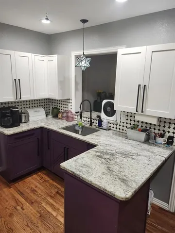 a kitchen with kitchen island granite countertop a sink and a wooden cabinets