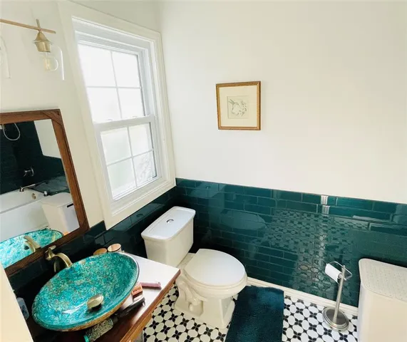 a bathroom with a toilet sink and mirror