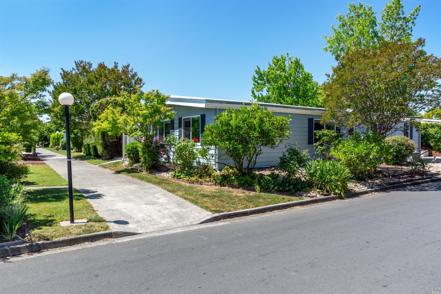 a front view of a house with a yard and potted plants