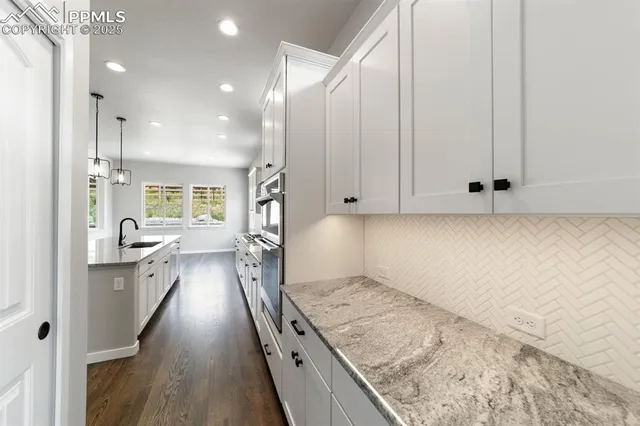 an open kitchen with kitchen island a sink stove and wooden floor
