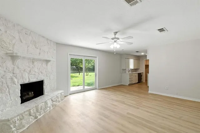 an empty room with windows and fireplace
