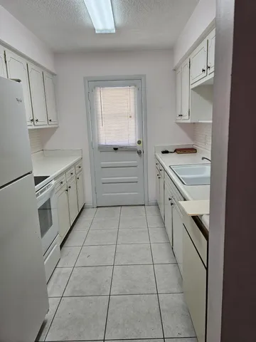 a kitchen with a stove sink and cabinets