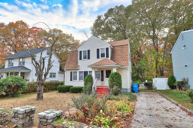 a front view of a house with a yard and trees