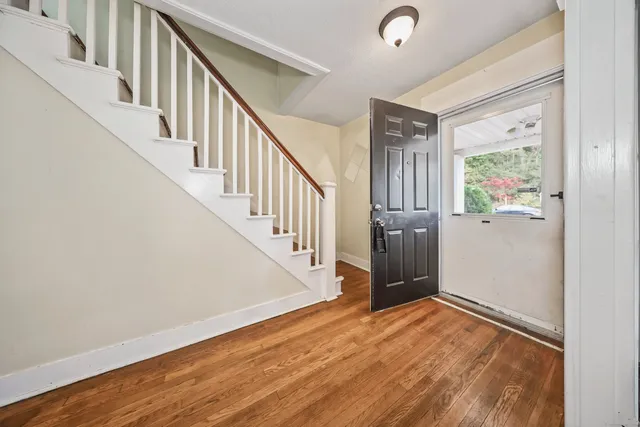 a view of an entryway with wooden floor and stairs