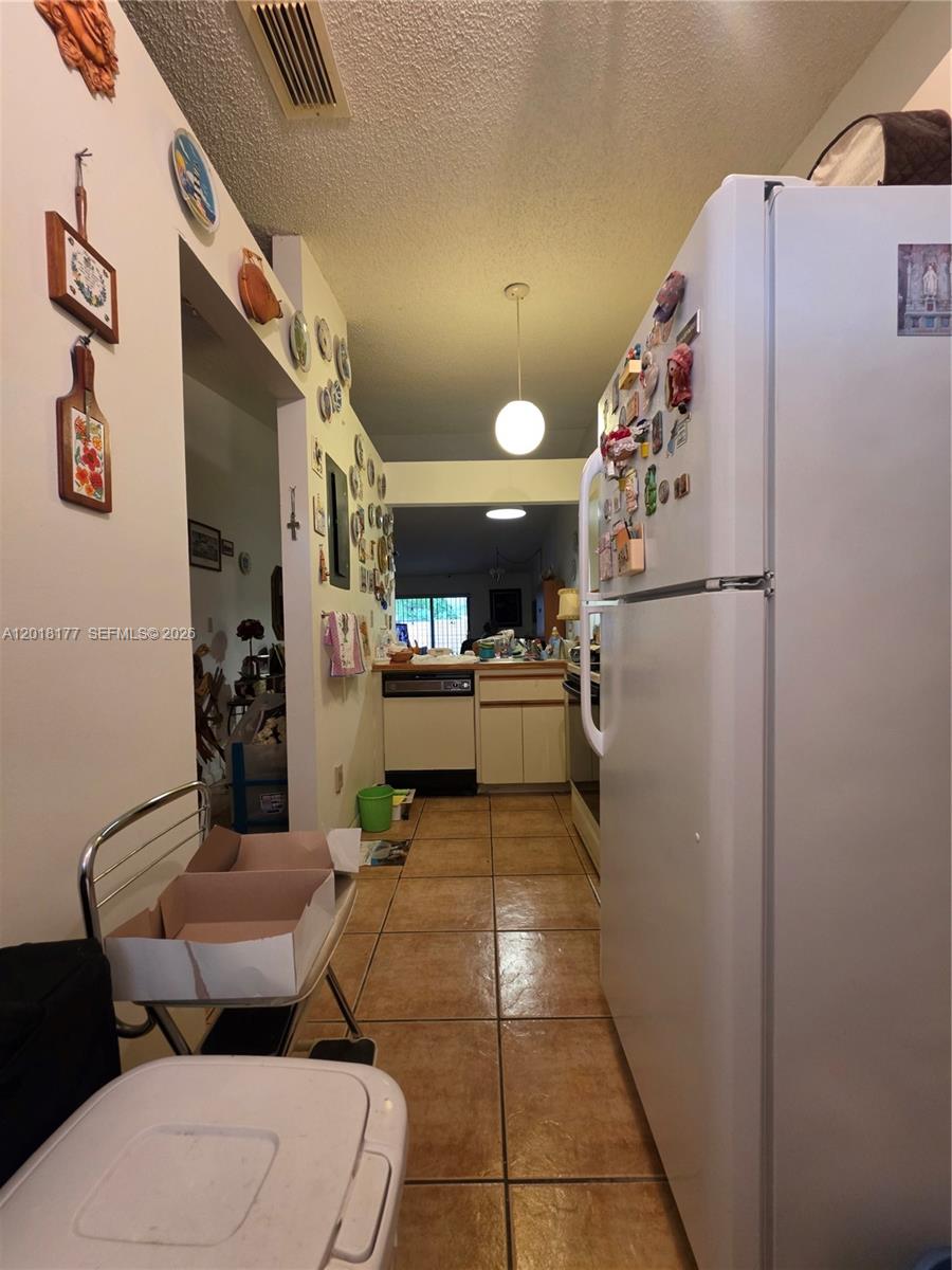 10908 Southwest 72nd Street, Unit 215 Miami, FL 33173 - Photo 6 of 25 a kitchen with a refrigerator and white cabinets