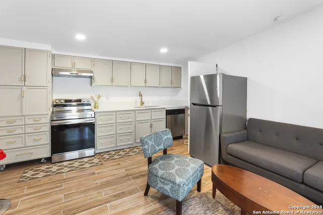 a kitchen with stainless steel appliances a stove a refrigerator and a refrigerator