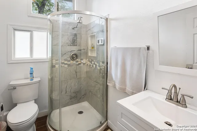 a bathroom with a sink a toilet and shower