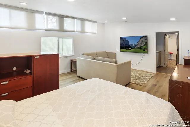 a bedroom with a large bed and a flat screen tv