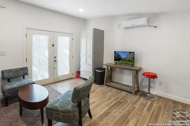 a living room with furniture a flat screen tv and kitchen view