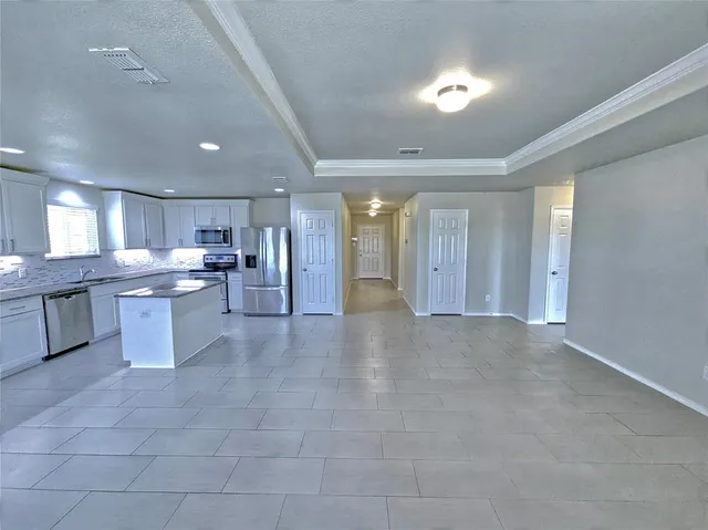 a view of a kitchen with refrigerator and cabinets
