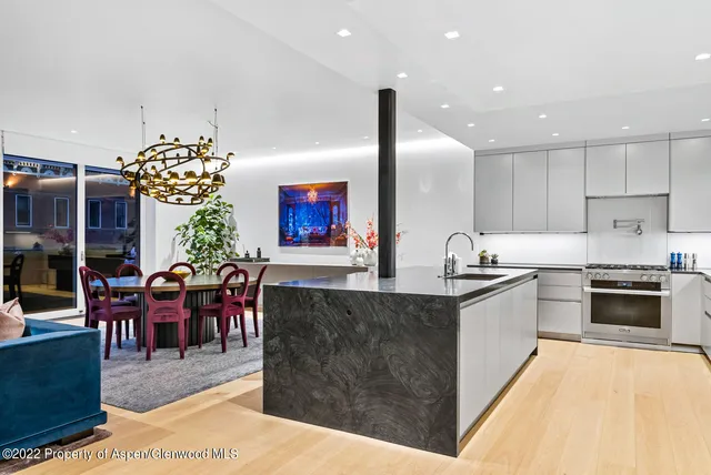 a large kitchen with stainless steel appliances kitchen island granite countertop a stove a refrigerator a dining table and chairs