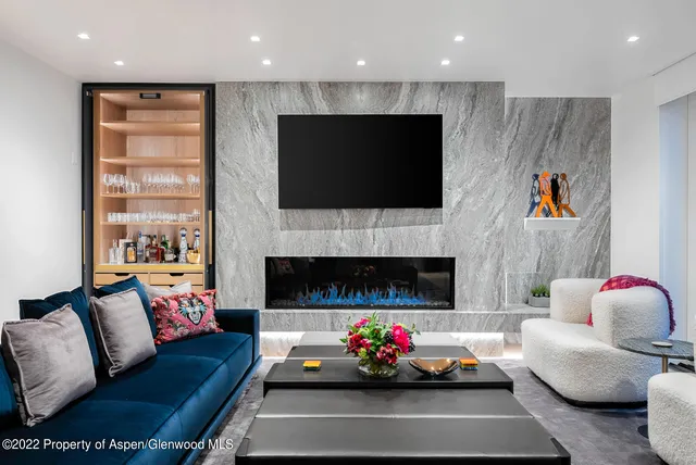 a living room with furniture a flat screen tv and a fireplace