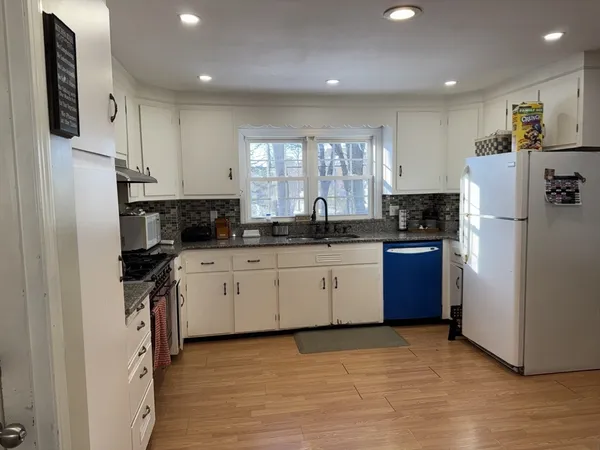 a kitchen with stainless steel appliances granite countertop a refrigerator sink and stove