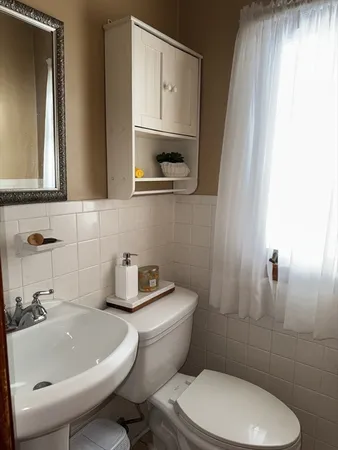 a bathroom with a sink a toilet and mirror