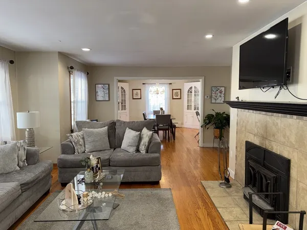a living room with furniture a flat screen tv and a fireplace