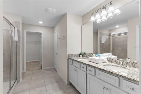 a bathroom with a granite countertop sink a large mirror and a shower