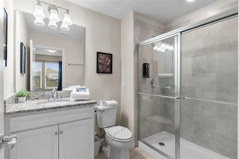 a bathroom with a granite countertop sink toilet and shower