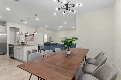 a kitchen with a table chairs sink and cabinets