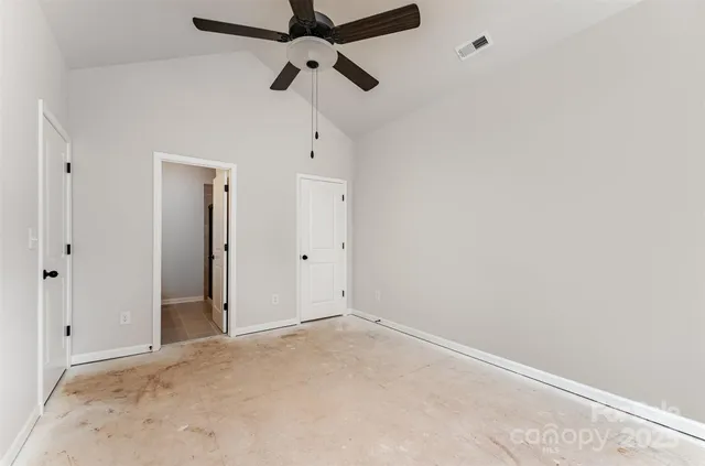 an empty room with chandelier fan
