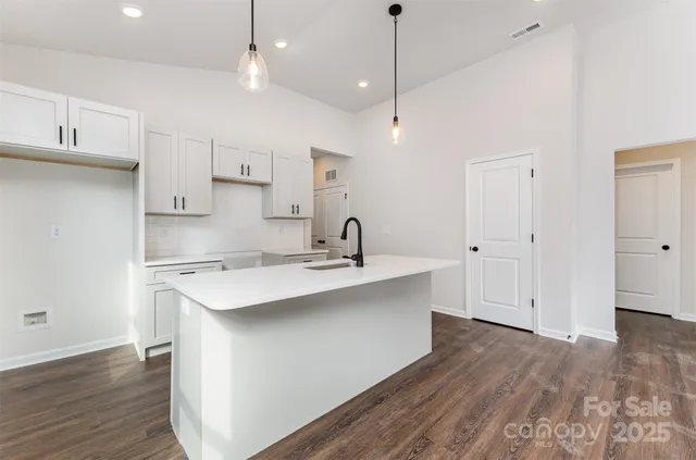 a kitchen with kitchen island a sink stainless steel appliances and cabinets