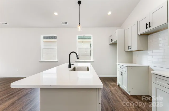 a kitchen with kitchen island a sink stainless steel appliances and cabinets
