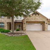 a front view of a house with a garden and yard