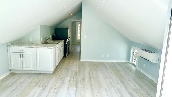 a kitchen with a sink and wooden floor