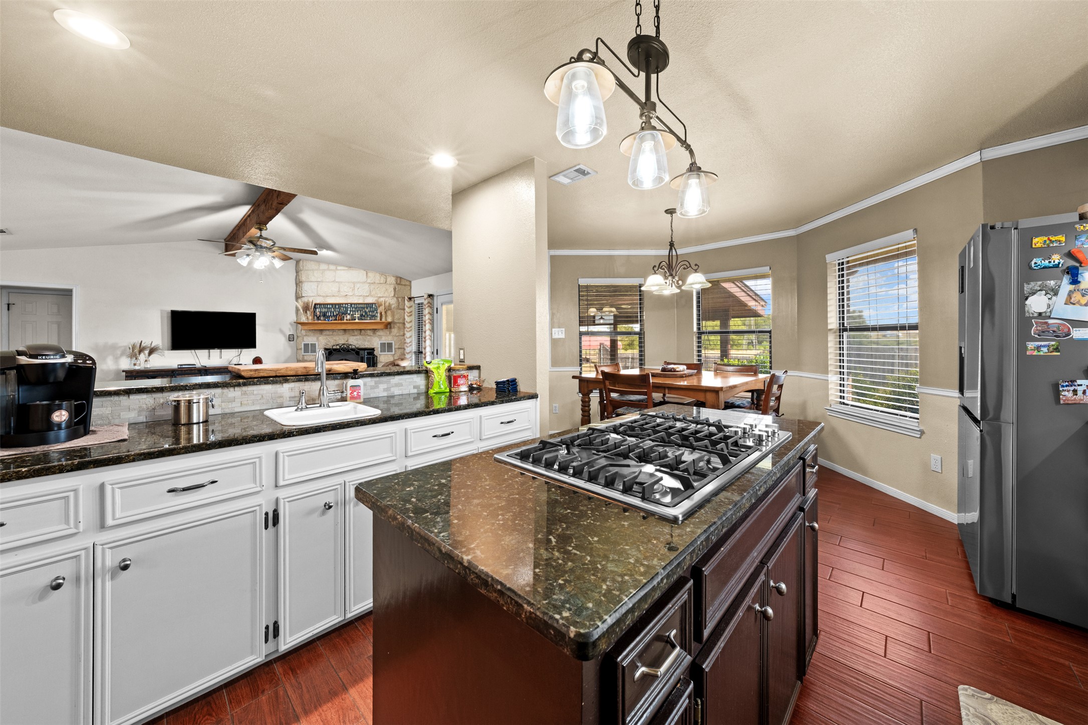 1512 Panther Loop Pflugerville, TX 78660 - Photo 26 of 40 A well-appointed kitchen features rich granite countertops and gleaming wood flooring, connecting to a dining nook.