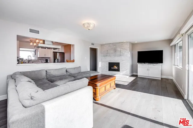 a living room with furniture a flat screen tv and a large window