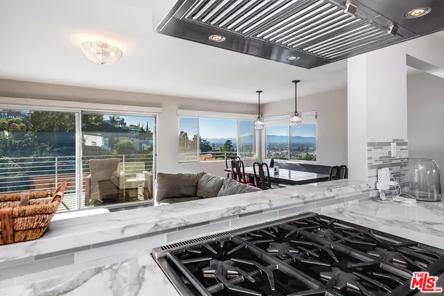 a kitchen with stainless steel appliances kitchen island granite countertop a sink stove and refrigerator