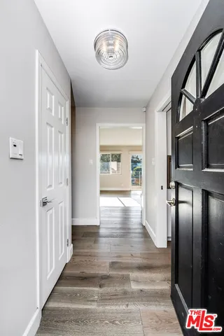 a living room with couches flat screen tv and a large window