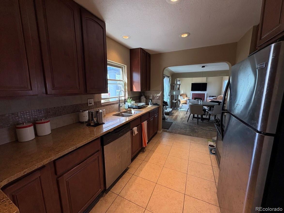 3520 High Court Wheat Ridge, CO 80033 - Photo 7 of 14 a kitchen with stainless steel appliances granite countertop a sink stove refrigerator and cabinets