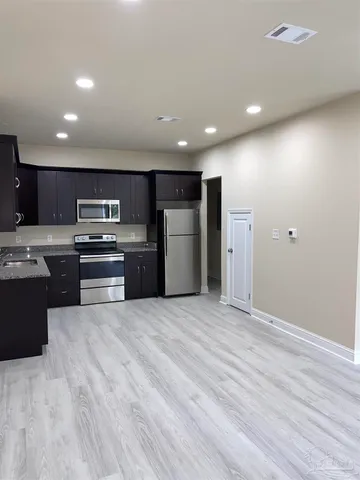 a kitchen with stainless steel appliances granite countertop a stove a sink and a refrigerator