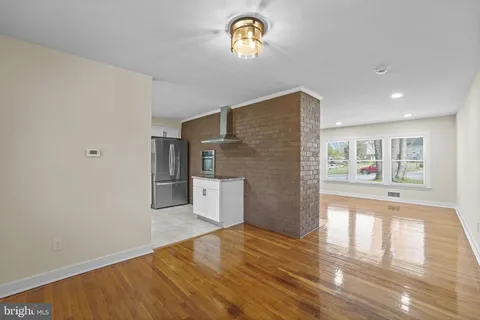 a view of empty room with wooden floor and window