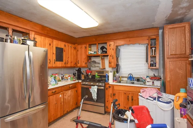 a view of a kitchen with fridge and workspace