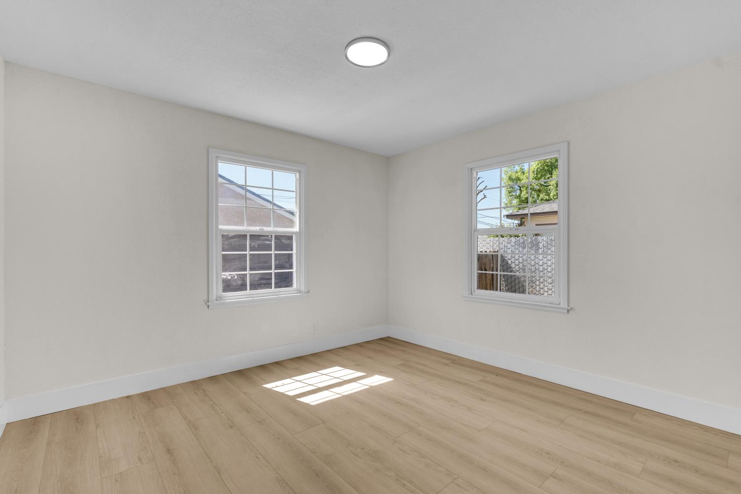 535 West Terrace Avenue Fresno, CA 93705 - Photo 8 of 18 an empty room with wooden floor and windows