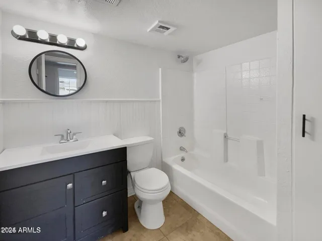 a bathroom with a toilet a sink a mirror and a bathtub