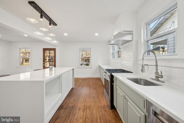 a kitchen with a sink cabinets and wooden floor