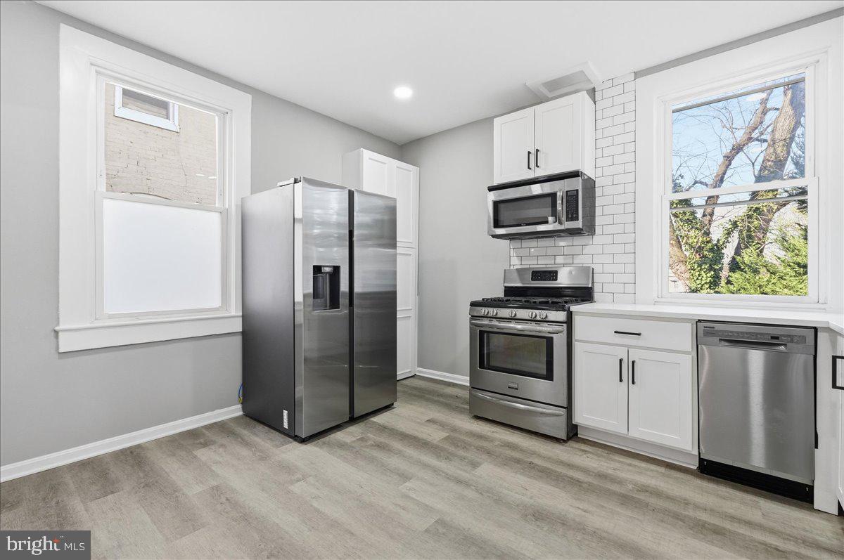 3414 Harford Road Baltimore, MD 21218 - Photo 11 of 32 a kitchen with granite countertop a refrigerator and a stove top oven