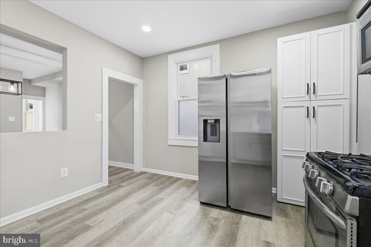 3414 Harford Road Baltimore, MD 21218 - Photo 13 of 32 a kitchen with granite countertop a refrigerator and a stove top oven