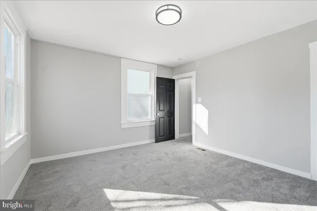 an empty room with windows and closet