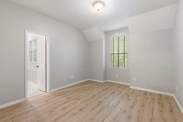 an empty room with a fireplace and wooden floor