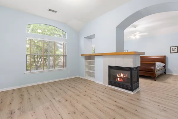 a view of a hallway with wooden floor and a fireplace