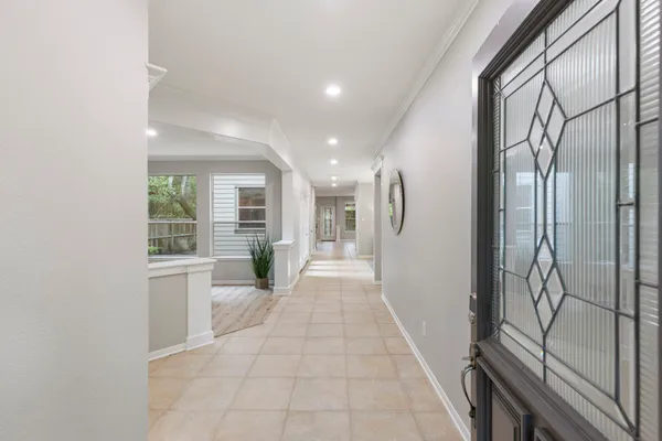 a view of a hallway with wooden floor and a kitchen