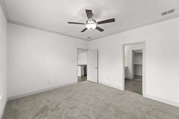 an empty room with closet and a ceiling fan