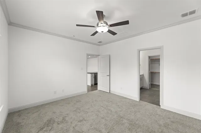 an empty room with closet and a ceiling fan