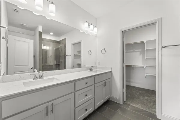 a bathroom with double vanity sink and a mirror