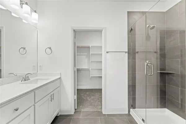 a bathroom with a shower sink and mirror