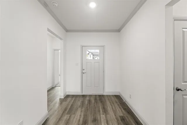 a view of an empty room with wooden floor and closet
